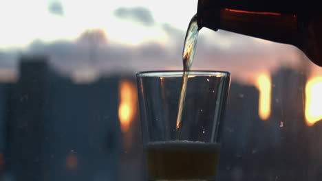 Beer-is-poured-into-a-short-glass-against-a-defocused-window