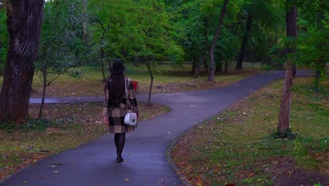 Fashionable-young-woman-is-walking-in-the-park-by-herself