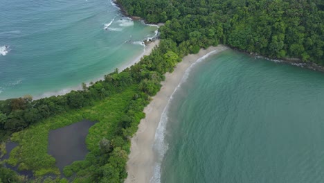Aerial-shot-of-Whale-tail-shaped-beach-in-Manuel-Antonio-National-Park,-Costa-Rica