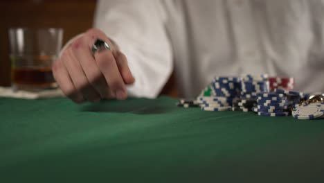 Gambler-pulls-in-winning-pot-of-chips-in-a-dark-moody-casino