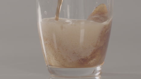 Cola-being-poured-in-glass-foaming-and-rising-to-surface---240-fps-slow-motion