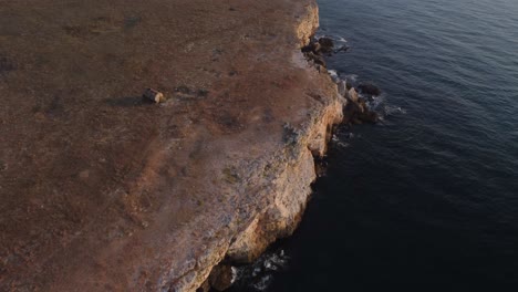 Drohne-Von-Oben-Nach-Unten-Luftaufnahme-Von-Wellen,-Die-Gegen-Die-Felsige-Küste-Spritzen,-Hintergrund