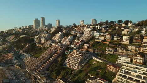 Aerial-view-rising-above-Reñaca-coastal-city-buildings-on-Vina-Del-Mar-holiday-beach-resort-waterfront