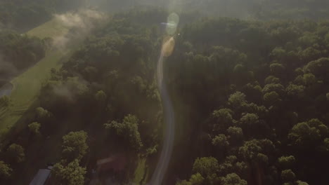 Revealing-drone-shot-of-the-sun-shining-on-a-road-in-Oak-Hill,-West-Virginia