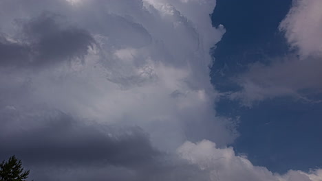 Low-Angle-Shot-Von-Flauschigen-Weißen-Wolken,-Die-Tagsüber-Am-Blauen-Himmel-Vorbeiziehen