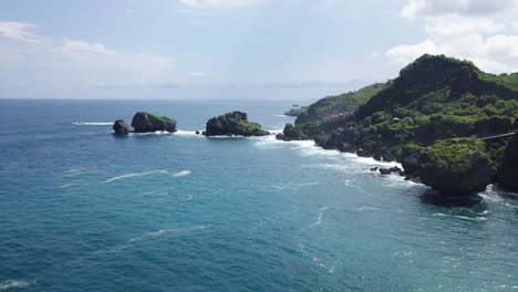 Drohnenaufnahme-Der-Koralleninsel-Am-Strand,-Die-An-Sonnigen-Tagen-Von-Wellen-Getroffen-Wird---Insel-Timang,-Yogyakarta,-Indonesien