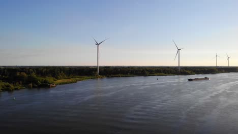 Aerial-Over-Oude-Maas-With-Still-Wind-Turbines-And-Silhouette-Of-Ship-Approaching-In-Distance