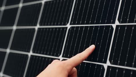 Person-touching-solar-panel-in-close-up,-concept-of-lower-electricity-prices