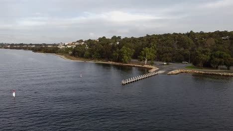 Aerial-Ascending-Flyover-Wide-River-And-Boat-Jetty,-Perth-Australia