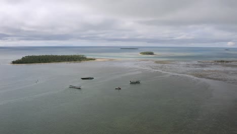 Aerial-slow-rise-over-old-fishing-boat-shipwrecks-stranded-in-shallow-water-off-Tongatapu