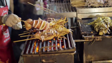 Gegrillter-Tintenfisch-Auf-Einem-Holzkohleofen-In-Yaowarat-Road-Chinatown,-Einem-Beliebten-Reiseziel-In-Bangkok,-Thailand