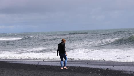 Woman-on-Black-Beach-picking-up-rocks