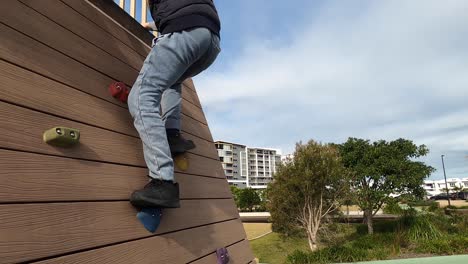 A-boy-climbs-a-rock-wall-located-at-a-public-park-in-Australia