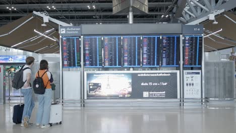 people-checking-flight-information-board-inside-the-airport-departure-terminal-Suvannabhumi-Airport-reopening-country