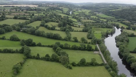 Lush-green-bucolic-countryside-pastures-and-small-picturesque-river