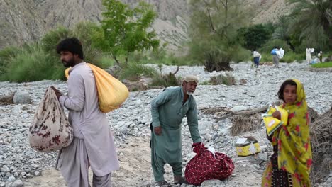 Familie,-Die-Mit-Hilfssäcken-In-Einem-Abgelegenen-Teil-Von-Belutschistan-Vorbeigeht