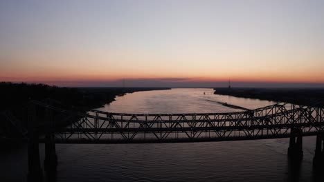 Wide-panning-aerial-shot-of-the-Natchez-Vidalia-Bridge-on-the-Mississippi-River-at-sunset