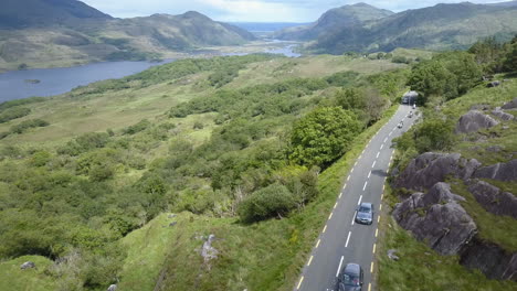 Aerial-video-of-Motor-bikes-and-cars-traveling-along-the-renowned-'Ring-of-Kerry',-part-of-the-tourist-route-"The-Wild-Atlantic-Way