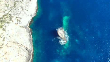 Drone-Disparó-Sobre-Rocas-Y-Acantilados-Con-Olas-Golpeando-Una-Pequeña-Roca-En-El-Mar-Mediterráneo-De-Malta-3