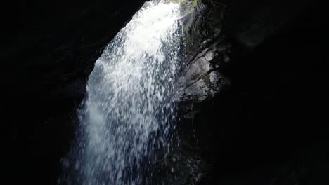 Water-falling-through-a-hole-into-a-cave-at-donut-falls-in-Big-Cottonwood-Canyon,-Utah