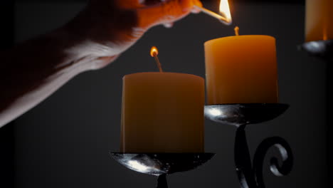 Man-lighting-candles-on-an-ornamental-candelabra