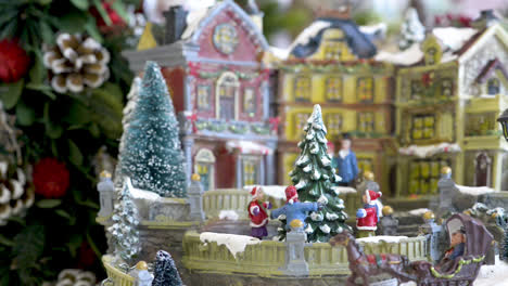 Süßes-Schneedorfspielzeug-Mit-Kindern,-Die-Um-Den-Weihnachtsbaum-Tanzen