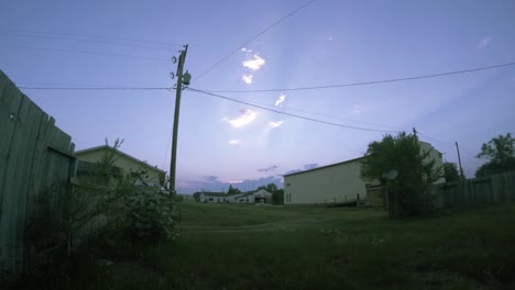TIME-LAPSE---Looking-across-a-field-during-to-day-with-the-sun-behind-moving-clouds