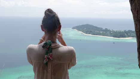 Ultra-slow-motion-shot-of-tourist-woman-taking-photos-of-island-in-Thailand-from-viewpoint