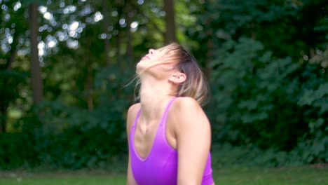 Pretty-woman-with-long-blonde-hair-doing-yoga-outside-in-a-park-moves-into-upward-facing-dog-position