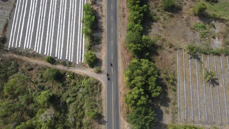 aerial-view,-drone-footage-following-a-speeding-motorbike-through-the-savanna-forest-on-the-southern-coast-of-yogyakarta