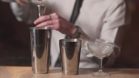 Professioneller-Barkeeper-Gießt-Wodka-In-Einen-Cocktailshaker