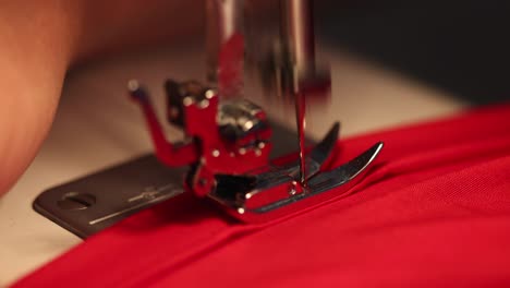 Female-hands-use-sewing-machine-on-red-dress-in-4K