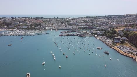 Aerial-footage-of-a-large-seaside-port-community-surrounding-a-marina-used-by-yachts-and-sailboats