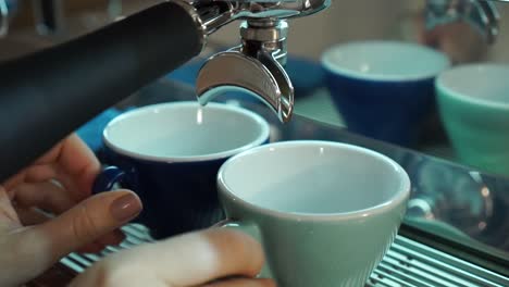 Professional-female-barista-prepares-two-porcelain-cappuccino-cups-of-espresso