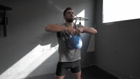 Young-athletic-man-doing-exercise-at-the-gym-with-kettlebell