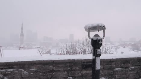 Heavy-snowfall-in-Tallinn-Estonia,-viewed-from-the-panoramic-platform-over-the-city-hiding-in-fog-and-snow