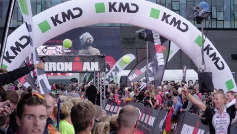 Stativaufnahme-Von-Drei-Personen,-Die-Beim-Kmd-Ironman-Copenhagen-2018-Auf-Die-Ziellinie-Zulaufen,-Während-Die-Menge-Jubelt