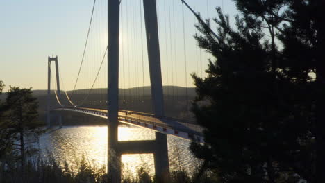 Car-driving-over-a-bridge,-at-a-sunny-evening,-at-Hoga-Kusten,-Vasternorrland,-Sweden