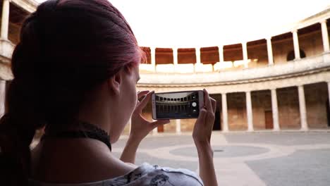 Rothaariges-Mädchen,-Das-Ein-Foto-Mit-Smartphone-Zu-Einem-Denkmal-In-Granada,-Spanien-Macht