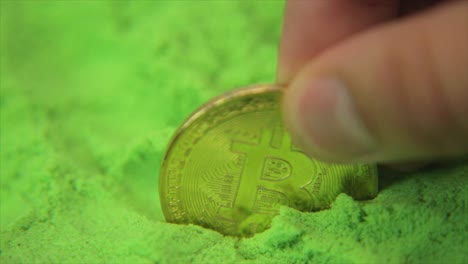 Dedos-Colocando-Bitcoin-En-Un-Mar-De-Verde