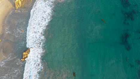 4k-ariel-drone-shot-of-crystal-clear-blue-waters-along-the-coast-of-a-gorgeous-sunny-beach