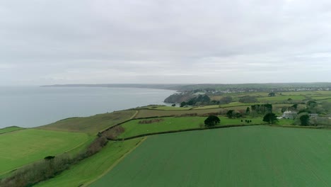 Aerial-tracking-over-fields-and-coastal-landscape-in-the-fertile-area-of-south-Devon,-near-Dartmouth