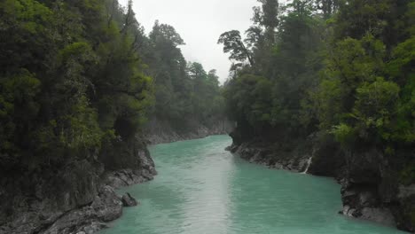 SLOWMO---Aerial-drone-flight-over-blue-glacier-river-at-Hokitika-Gorge,-New-Zealand