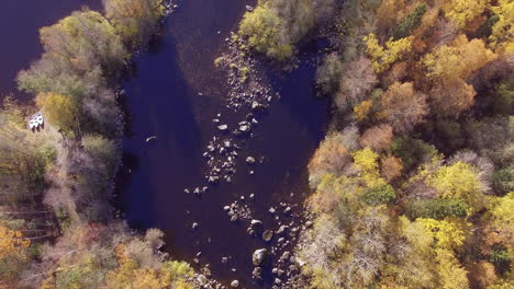 Wunderschönes-Drohnen-Überflugvideo-Eines-Flusses-In-Der-Wildnis-Mit-Drei-Booten-An-Land,-Die-Darauf-Warten,-Zum-Angeln-Zu-Gehen