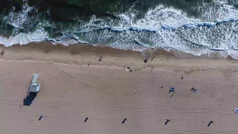 Birds-eye-view-of-waves-on-beach,-shot-on-a-drone-looking-directly-down-at-amazing-waves-washing-over-the-sand