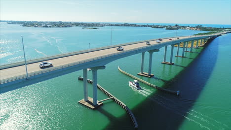 Aerial-shot-of-cars-and-boats-on-and-around-Belleair-Bridge-by-Clearwater-Beach,-Florida