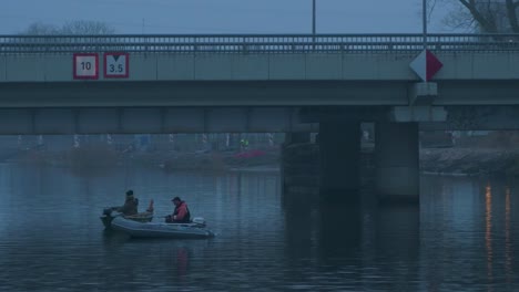 Fisherman's-catching-fish-with-fishing-rods-in-the-Liepaja-Trade-canal-in-foggy-afternoon-from-boat-near-the-bridge