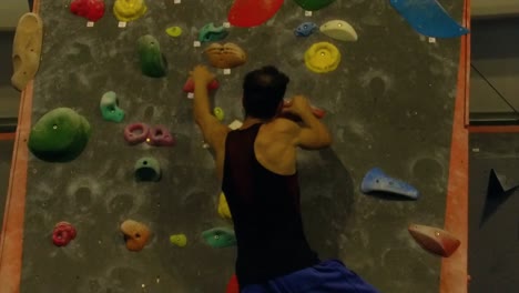 Slow-motion-view-of-a-man-practicing-indoor-climbing