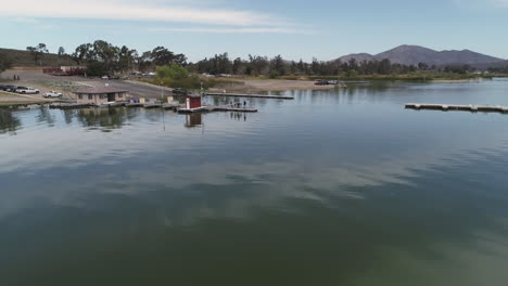 AERIAL:-Hovering-Drone-Shot-of-Dock-on-a-Green-Lake