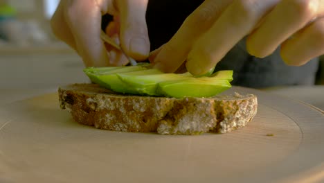 Slow-motion-shot-of-white-woman-making-avocado-toast